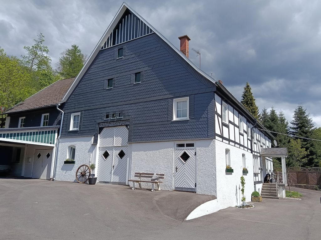 das Bild zeigt das Fachwerk-Bauernhaus mit Schieferverkleidung aus dem Jahr 1838 auf Hof-Naturverbunden